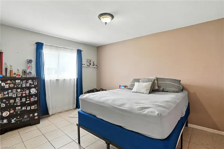 Bedroom with light tile patterned floors and baseboards