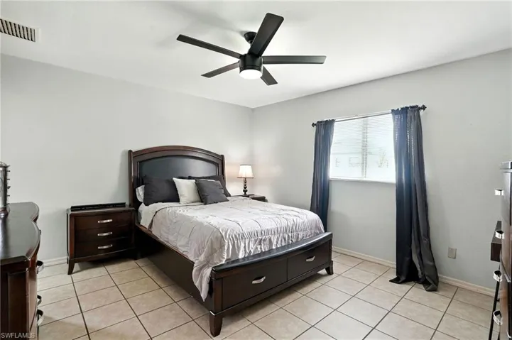 Bedroom featuring light tile patterned floors and ceiling fan