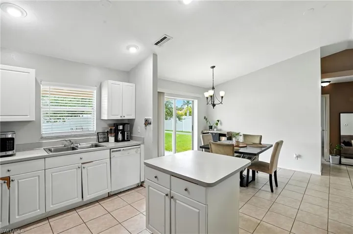 Kitchen featuring white cabinetry, light tile patterned floors, and dishwasher