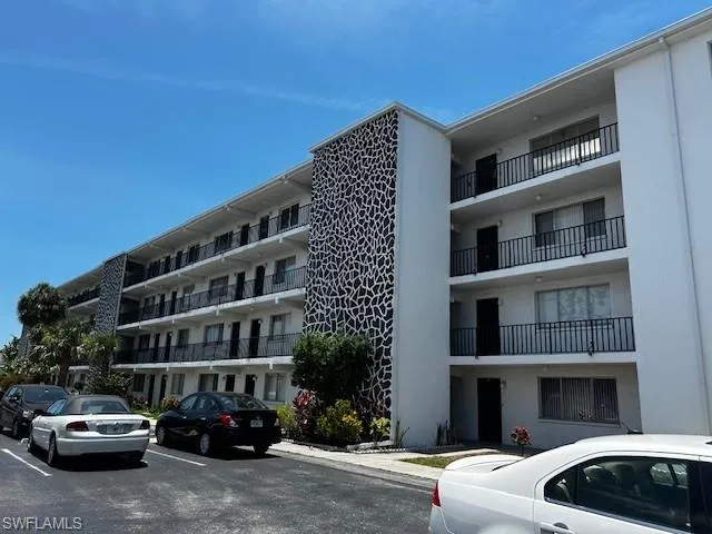 View of apartment building / complex with uncovered parking
