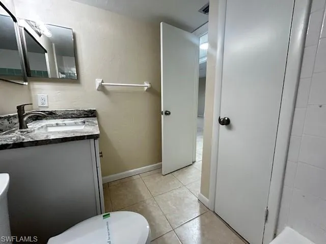 Bathroom featuring a textured wall, vanity, and light tile patterned floors