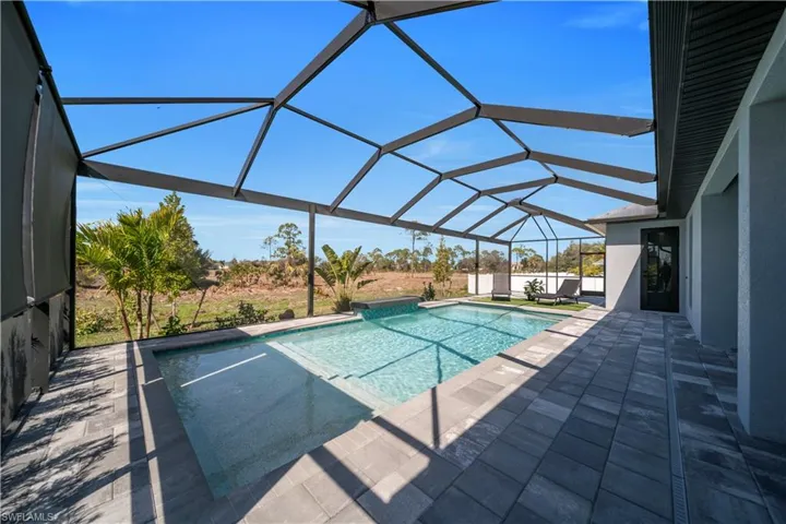 Swimming pool featuring a sunroom, a patio area, and a lanai