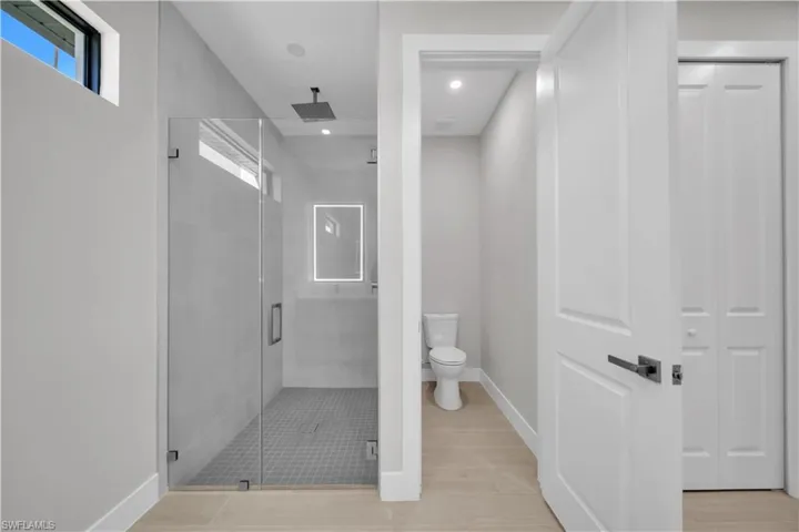 Full bathroom with a shower stall, recessed lighting, a closet, and light wood-type flooring