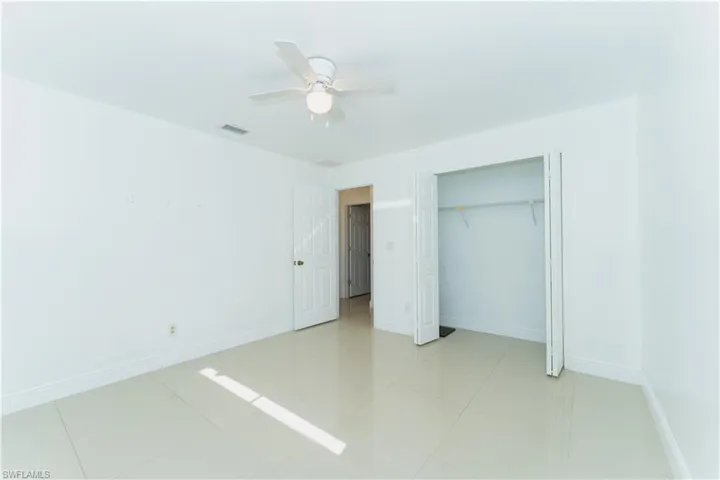 Unfurnished bedroom featuring ceiling fan, a closet, and light tile patterned floors