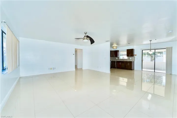 Unfurnished living room featuring a ceiling fan and light tile patterned floors
