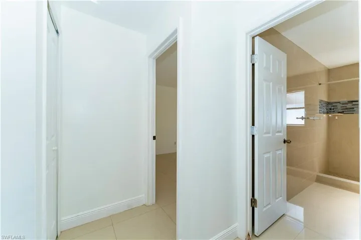 Full bathroom featuring tiled shower and light tile patterned flooring
