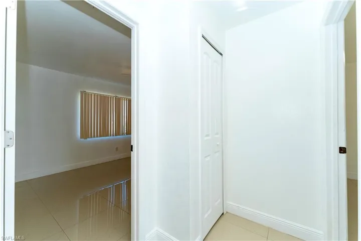 Corridor with light tile patterned floors and baseboards