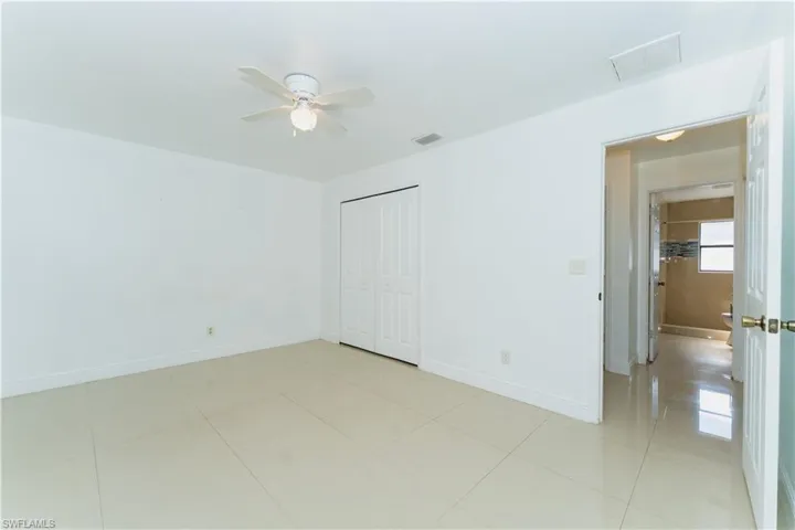Unfurnished bedroom featuring a closet, a ceiling fan, and light tile patterned floors