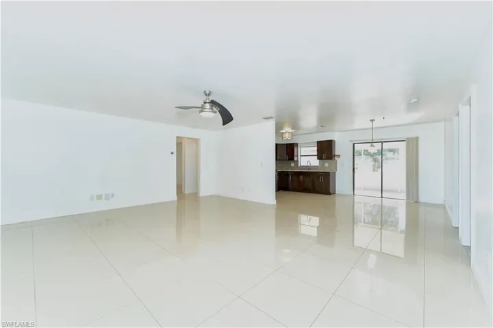 Empty room featuring a ceiling fan and light tile patterned floors