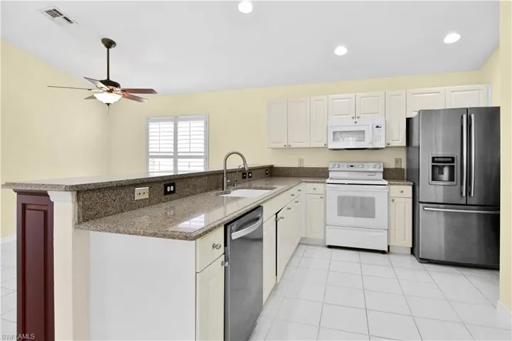 Kitchen with quartz counters and French door Refrigerator