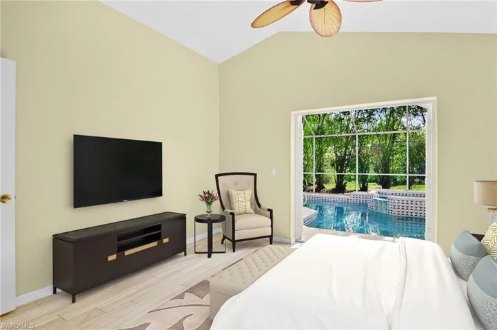Primary bedroom featuring ceiling fan, plank tile flooring, vaulted ceiling and French doors leading to the pool.