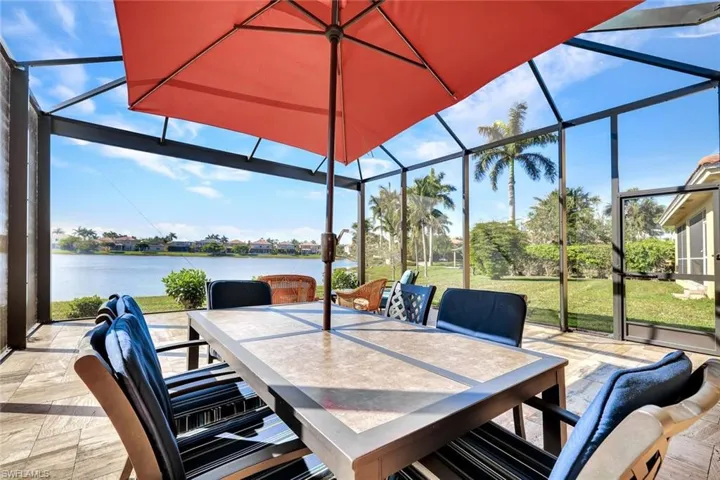 View of patio / terrace featuring a water view and glass enclosure