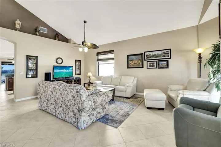 Tiled living room with high vaulted ceiling and ceiling fan