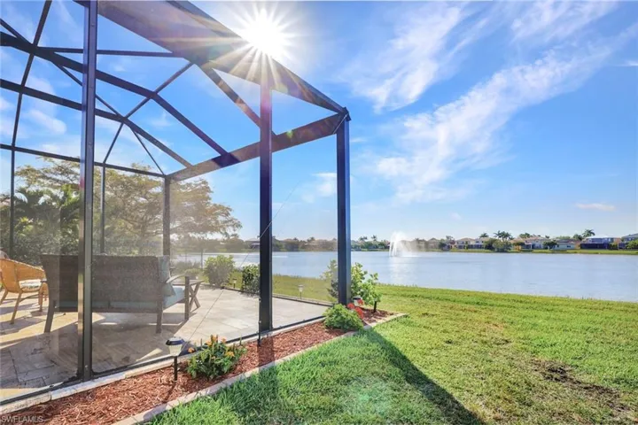 View of yard featuring a water view, a patio area, and glass enclosure
