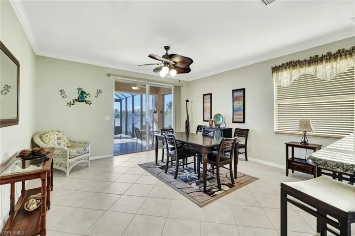 Dining space with crown molding, light tile patterned flooring, and ceiling fan