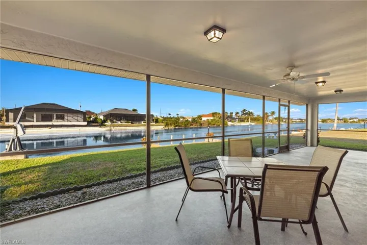 Sunroom / solarium featuring ceiling fan and a water view