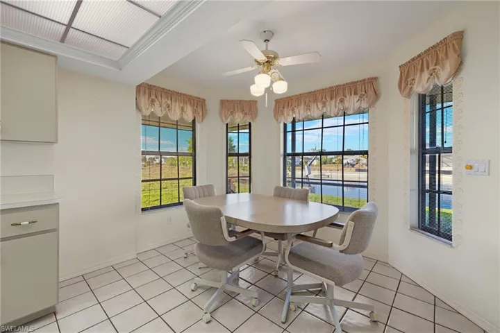 Tiled dining room with a wealth of natural light and ceiling fan