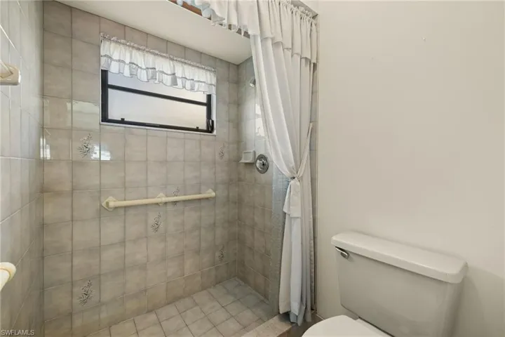 Bathroom with toilet and curtained shower