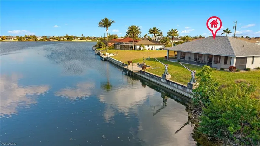 View of dock featuring a lawn and a water view