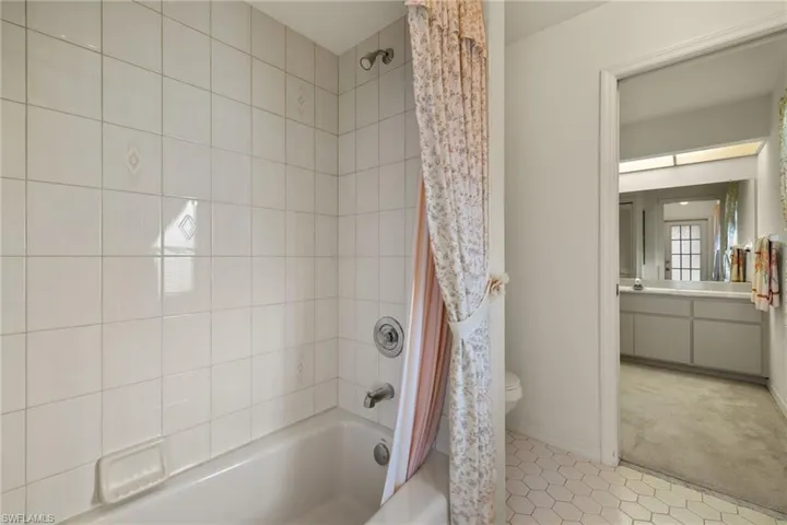 Full bathroom with vanity, shower / bath combination with curtain, and toilet