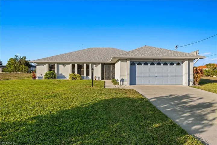 Single story home with a garage and a front yard