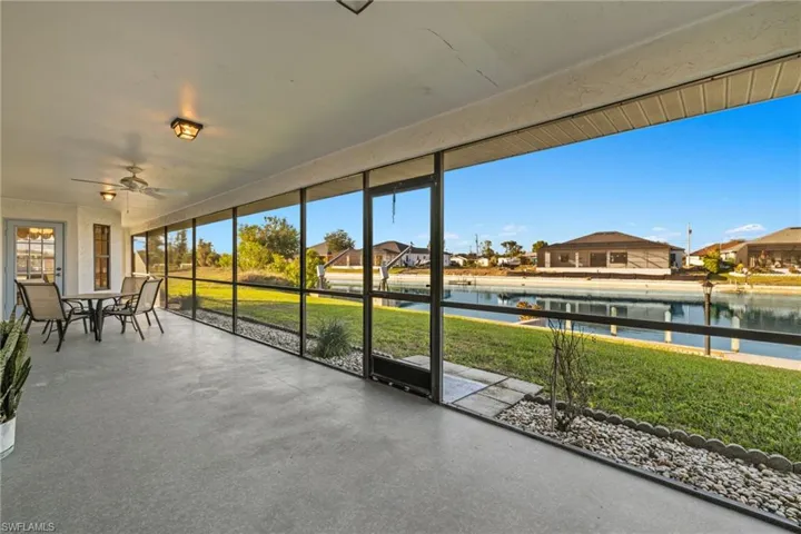 Unfurnished sunroom featuring ceiling fan and a water view