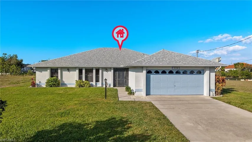 Ranch-style house featuring a garage and a front lawn