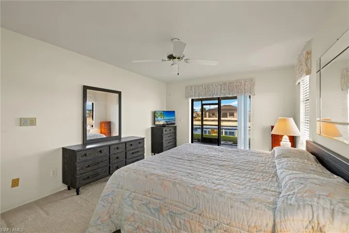 Bedroom featuring access to outside, light colored carpet, and ceiling fan