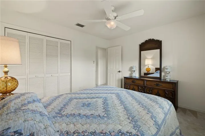 Bedroom featuring a closet, ceiling fan, and carpet