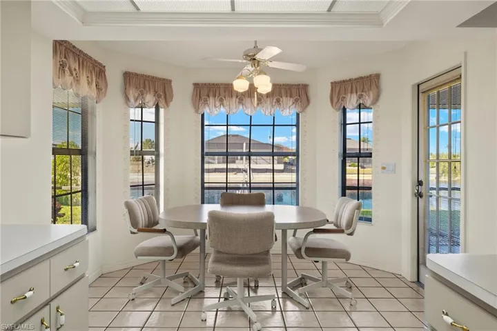 Sunroom featuring a raised ceiling and ceiling fan