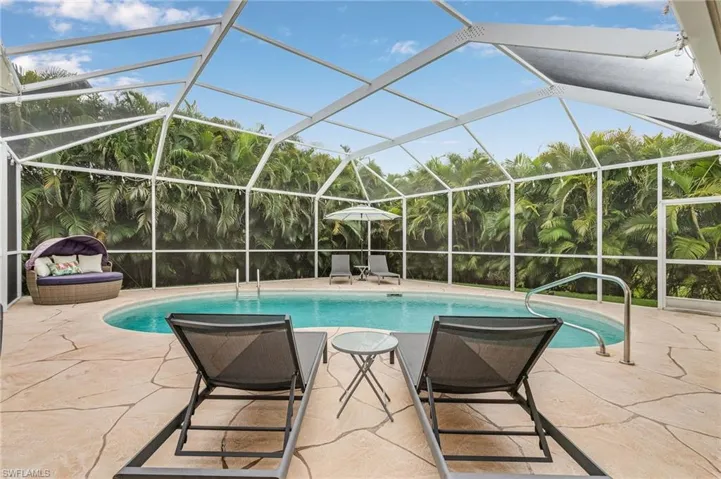 View of pool featuring a patio and glass enclosure
