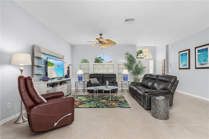Living room with ceiling fan and light tile floors
