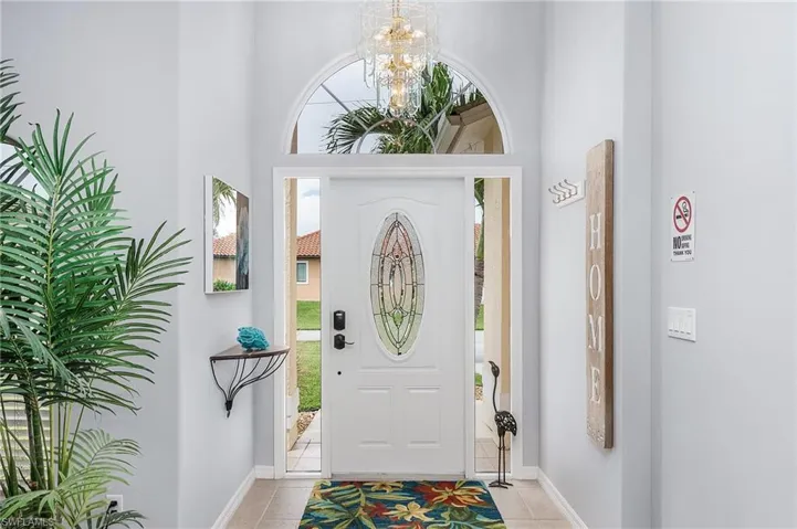 Tiled foyer with an inviting chandelier