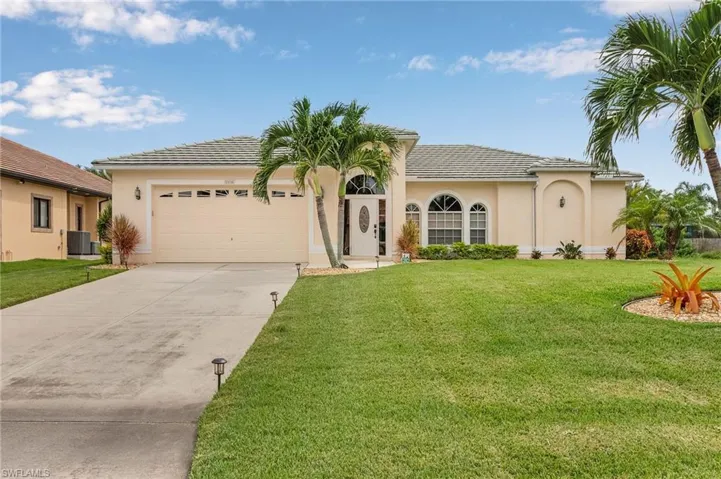Mediterranean / spanish-style home featuring a front lawn, a garage, and central AC unit