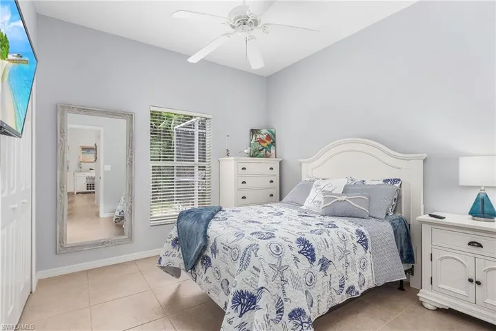Bedroom with a closet, ceiling fan, and light tile floors