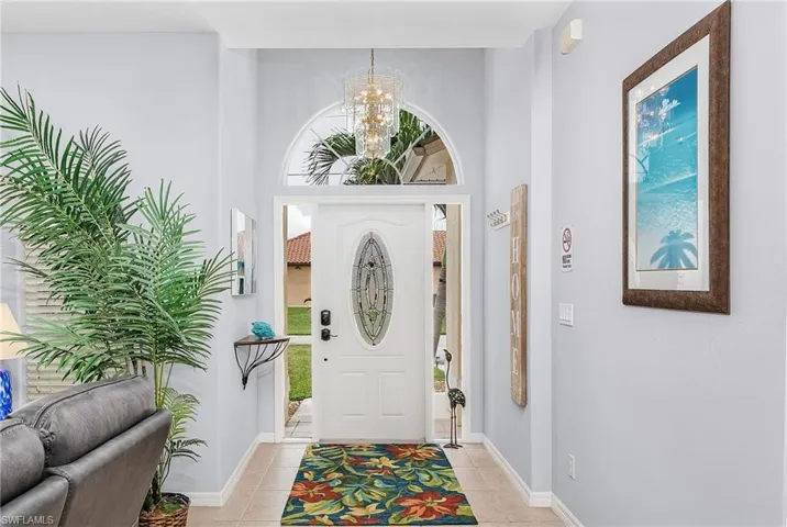 Tiled foyer entrance featuring a notable chandelier and plenty of natural light