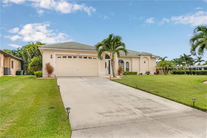 View of front of house with a garage, a front yard, and central air condition unit