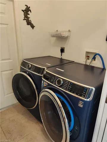 Clothes washing area featuring washing machine and dryer, hookup for a washing machine, and electric dryer hookup
