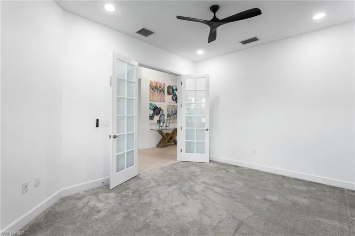 Spare room featuring french doors, carpet flooring, a ceiling fan, and recessed lighting