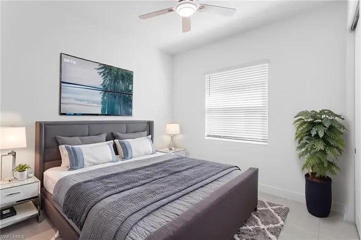 Bedroom with light tile patterned floors and ceiling fan