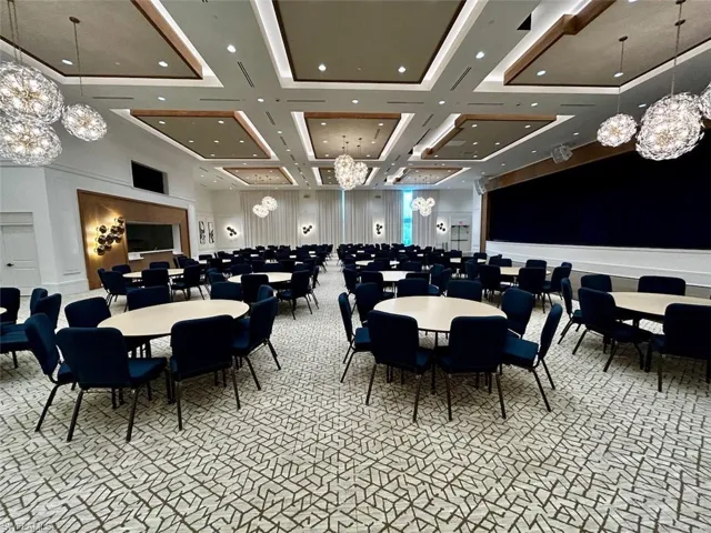 Dining room with a chandelier, coffered ceiling, and a high ceiling