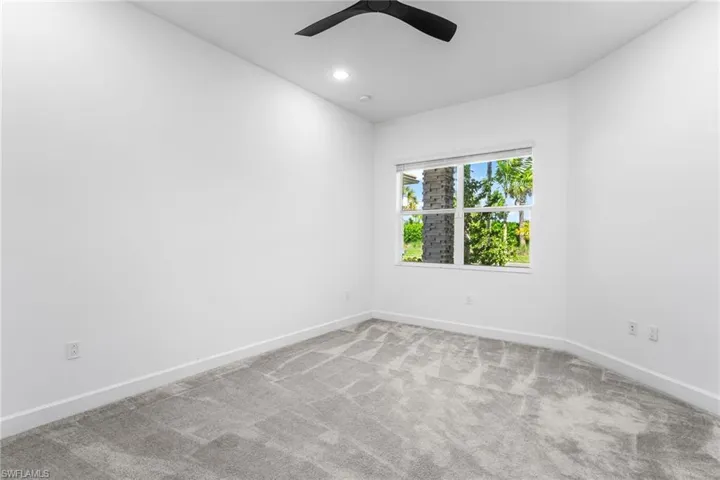 Empty room with light colored carpet and recessed lighting