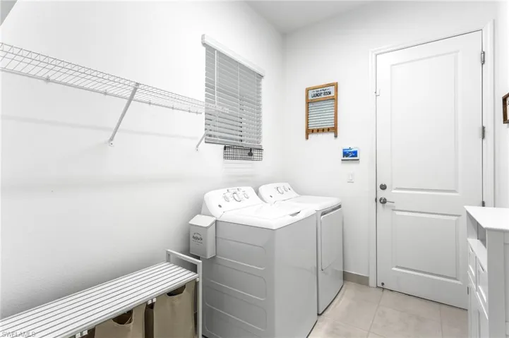 Laundry area with light tile patterned floors and washer and dryer