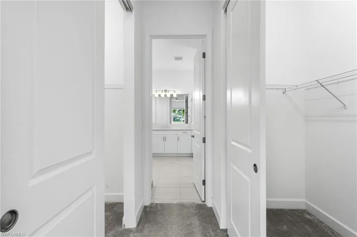 Corridor featuring carpet and tile patterned flooring
