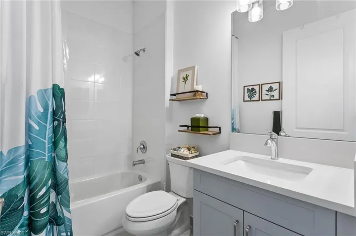 Full bath with shower / bath combo with shower curtain and vanity