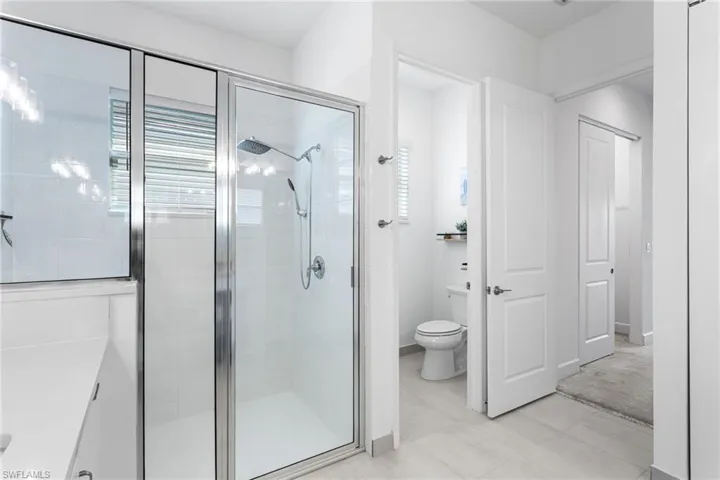 Full bath featuring a shower stall and light tile patterned flooring