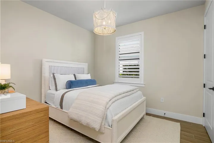 Additional guest room with plantation shutters, designer lighting, and another walk-in closet!