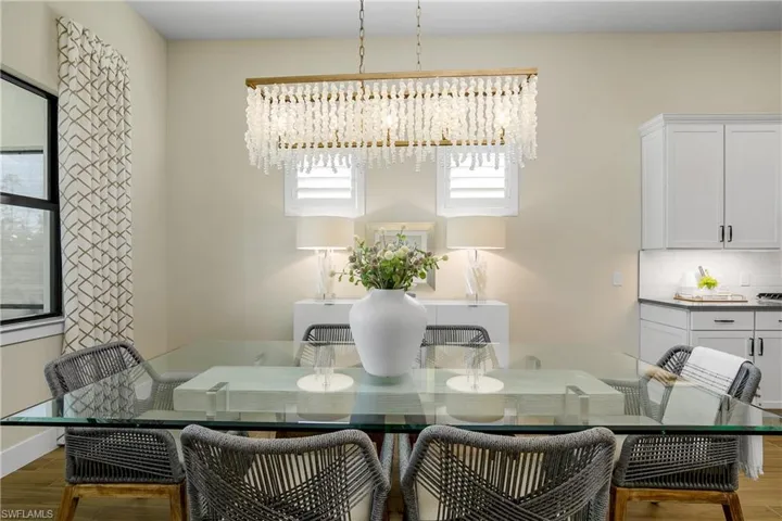 Dedicated Family dining space features plantation shutters, custom drapery, and exquisite chandelier.