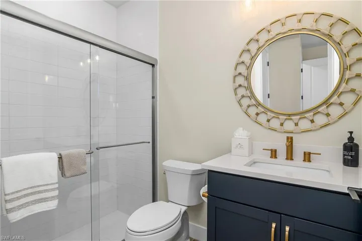 Guest bath with walk-in shower and custom mirror and lighting.