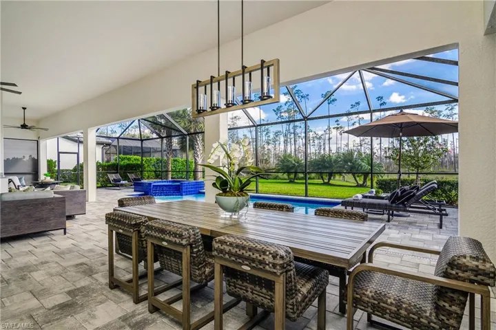 Outdoor dining area with designer lighting and Kevlar storm shades surrounding entire covered living area.